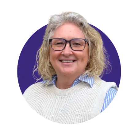 Lady with curly blonde hair and black rimmed glasses